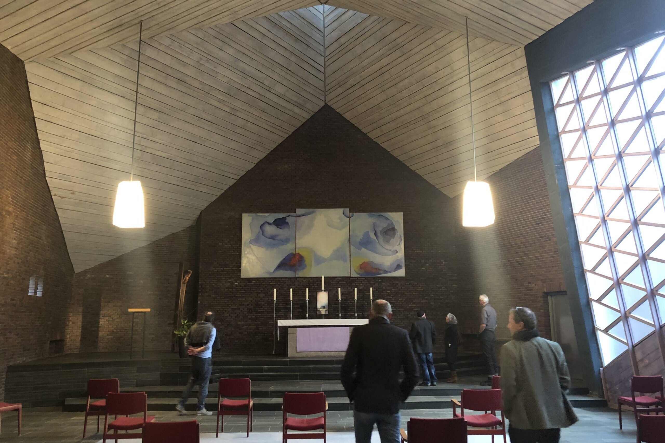 Innenraum einer Kirche der Anthroposophischen Christengemeinschaft mit schlichter Architektur, Altar und Besuchern, die Besinnung und Gemeinschaft erleben.