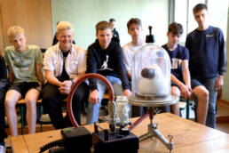 Schüler beobachten ein Experiment im naturwissenschaftlichen Unterricht, das komplexe Zusammenhänge auf anschauliche Weise vermittelt.